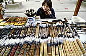 A beautiful Chinese woman sells Calligraphy brushes in Xian, China
