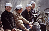 Muslim men sit and relax in the grounds of the beautiful old mosque in the old city of Xian, China
