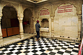 A man holds a pray to the holy rats in this fascinating temple near Bikaner, Rajasthan, India