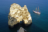 A sailing ship off the rocky coast in the sunlight, Ponta da Piedade, Algarve, Portugal, Europe