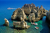 Boats off the rocky coast in the sunlight, Ponta da Piedade, Algarve, Portugal, Europe