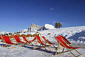 Rote Liegestühle im Schnee, Seiser Alm, Dolomiten, Trentino-Südtirol, Italien