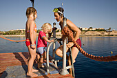 Mother with children, girls, about to go snorkelling, Lamaya Resort, Coraya