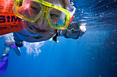 Child, girl, 5, with inflatable armbands and her mother snorkeling in the sea at the Lamaya Resort coral reef, Coraya, Marsa Alam, Red Sea, Egypt