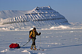 Ski tourer hauling sledge on spring traverse Ny Alesund to Longyearbyen Spitsbergen Island Svalbard Norwegian Arctic