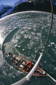 Yacht breaking ice while cruising up west arm of Seno fjord Pia Isla Grande Tierra del Fuego Chile