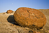 Exposed concretion boulders in and rising moon in Red Rock Coulee
