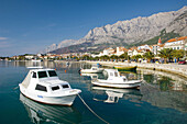 The harbour with a waterfront walk and fishing boats in Makarska, Croatia