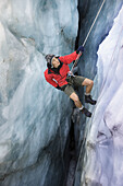 Mountain guide abseiling in glacier crevasse