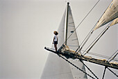 Woman standing on the bow of a classic ship.