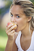 Young woman eating fruit.