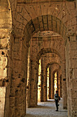 Tunisia, Eljem, Roman Colesium, tourist admiring the interior vaults