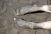 Spain. Canary islands. Gran Canaria. Las Palmas. Las Canteras beach. Volcanic sand on feet.