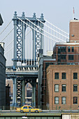 Brooklyn Bridge and taxi in foreground, NYC, USA