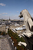 France. Paris. A gargoyle on the Galerie des Chimeres of Notre_Dame Cathedral with the view of La Cite in the background.