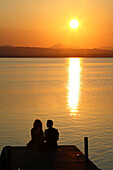 View of a couple watching the sunset.