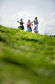 Three girls wearing dirndl in a meadow, Muensing, Bavaria, Germany
