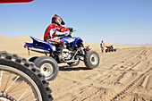 Quad drivers on sand dunes near Swakopmund, Namibia, Africa