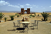 Table and chairs on a terrace in the sunlight, view at a gate, Draa valley, South Morocco, Morocco, Africa