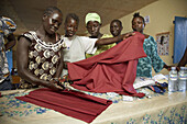 SOUTH SUDAN  Loka Womens Association  Tailoring workshop  Demonstrating cutting cloth prior to making garments