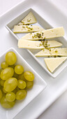 Grapes and cheese with herbs and olive oil