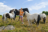 Small girl in a pony herd.