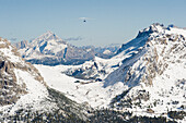 Drachenflieger über schneebedeckten Dolomiten, Südtirol, Italien