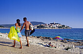 Menschen auf der Strandpromenade unter blauem Himmel, Primosten, Kroatische Adriaküste, Dalmatien, Kroatien, Europa