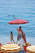 Bademeister am Strand unter einem Sonnenschirm, Monterosso al Mare, Cinque Terre, Italienische Riviera, Ligurien, Italien, Europa