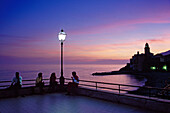 Menschen sitzen auf einer Strandterrasse in der Abenddämmerung, Camogli, Italienische Riviera, Ligurien, Italien, Europa