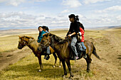 Young Mongolian nomads on their horses