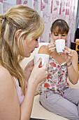 Two young women drinking coffee