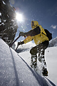 Mountaineer climbing snow covered mountain