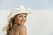 portrait of a woman wearing a hat by the sea