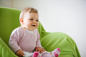 Baby girl (8 month) sitting in an armchair, Vienna, Austria