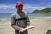 Fischer hält einen kleinen Hai, Playa Guayacan, Isla Margarita, Nueva Esparta, Venezuela
