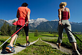Ein junges Paar beim Nordic Walking in idyllischer Landschaft, Tirol, Österreich, Europa