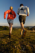 Paar joggt im Licht der Abendsonne, Fränkische Schweiz, Bayern, Deutschland, Europa