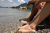 Two people bathing their feet in the water of a lake, Lake Tegernsee, Upper Bavaria, Bavaria, Germany