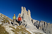Couple hiking in the mountains, Vajolet towers in the background, Rosengarten, Dolomites, Trento, South Tyrol, Italy