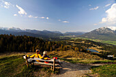 Couple hiking, enjoying the view from Kranzberg, View towards the Karwendel, Mittenwald, Upper Bavaria, Bavaria, Germany, Europe