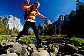 Frau mittleren Alters springt über Felsen, Yosemite-Nationalpark, Kalifornien, USA