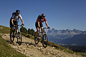 Two mountain bikers on dirt road, Rosengarten, Trentino-Alto Adige/Südtirol, Italy