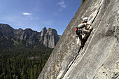 Woman climbing on rock face, Yosemite National Park, California, USA