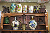 Antique pottery items for sale on shelving outside an antique shop, Sighisoara, Transylvania, Romania
