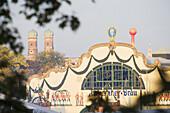 Oktoberfest beer tent, spires of the Frauenkirche in background , Munich, Bavaria, Germany