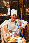 Älterer Mann raucht eine Wasserpfeife im Café Fishawi im Bazaar Khan el-Khalili, Kairo, Ägypten, Afrika