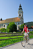 Female cyclist, abbey church, Engelszell Abbey, Danube Cycle Route Passau Vienna, Engelhartszell, Upper Austria, Austria