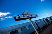 Railway station sign in front of The Ghan transcontinental train, Darwin, Northern Territory, Australia