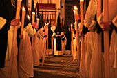 Easter Parade, procession of candleholders at night with the leader, Seville, Andalucia, Spain